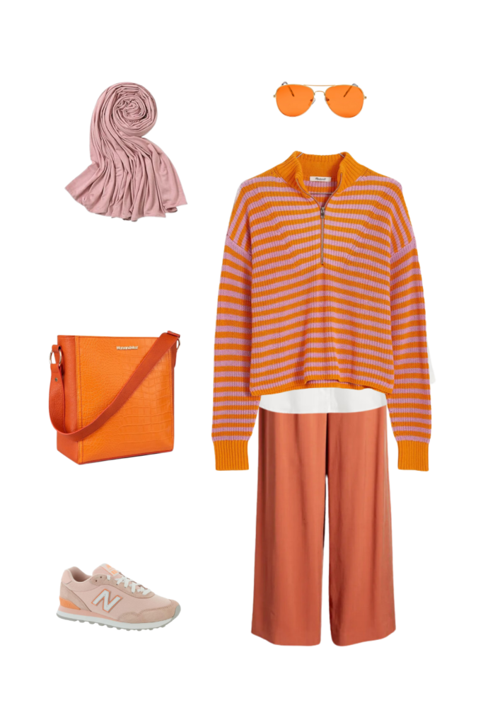 A stylish, modest fall outfit featuring an oversized burnt orange sweater paired with wide-leg brown trousers and a matching brown hijab. The look is completed with casual white sneakers, a brown shoulder bag, and gold accessories, creating a warm and cozy autumn aesthetic that’s both comfortable and sophisticated. Ideal for fall and winter layering, this outfit blends comfort with a refined, casual vibe, making it perfect for work, coffee dates, or weekend outings.